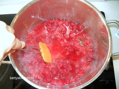 kook de fambozen in een pan om frambozen jam te maken