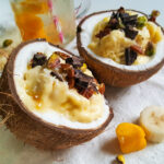 recept voor een tropisch dessert in een kokosnoot met banaan en mango