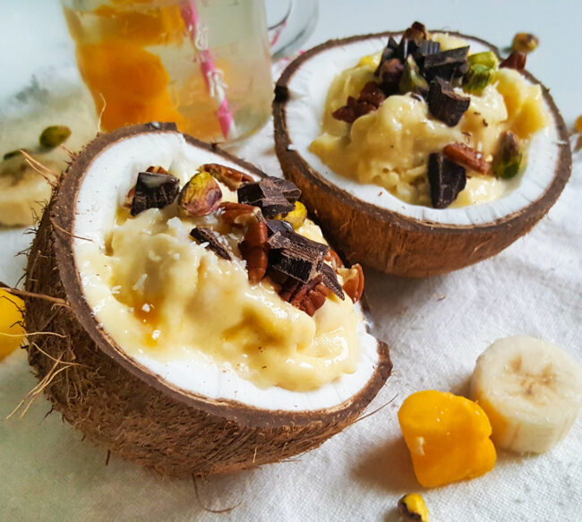 recept voor een tropisch dessert in een kokosnoot met banaan en mango