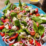 zomerse Griekse salade met linzen olijven, rode ui, tomaten en spinazie